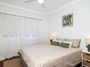 a white bedroom with a bed and a window at 31 Beech Street in Evans Head