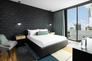 a bedroom with a bed and a chair and a window at Downtown Grand Hotel & Casino in Las Vegas