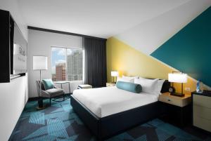 a hotel room with a bed and a chair at Downtown Grand Hotel & Casino in Las Vegas