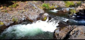 una vista aerea di un fiume con rocce e acqua di Vista al volcán con tinaja y río en Conguillío a Curacautín