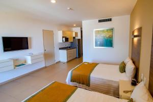 a hotel room with a bed and a tv at Pacific Palace Beach Tower Hotel in Mazatlán