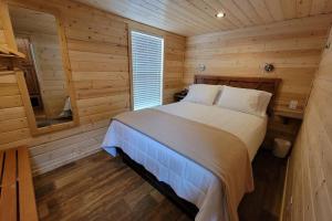 ein Schlafzimmer mit einem Bett in einer Holzhütte in der Unterkunft 079 Tiny Home nr Grand Canyon South Rim Sleeps 8 in Valle