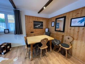 een eetkamer met houten wanden en een houten tafel en stoelen bij Suite Home Mittenwald in Mittenwald