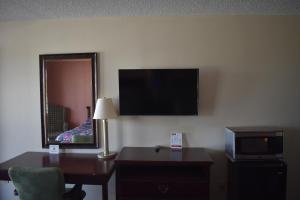 a hotel room with a desk and a tv and a mirror at Royal Inn in Springdale +41 photos