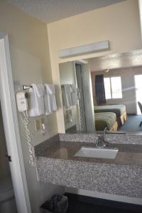 Zimmer mit Waschbecken und Spiegel in der Unterkunft Royal Inn in Springdale