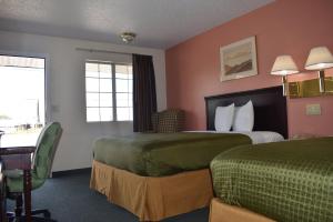 a hotel room with two beds and a desk at Royal Inn in Springdale