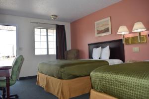 斯普林代尔Royal Inn的有两张床和一张书桌的酒店房间