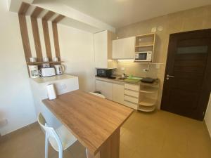 una pequeña cocina con una mesa de madera en una habitación en Apart Guemes en Salta