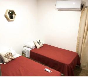 een kamer met 2 bedden met rode lakens bij Depto Temporario Entre Rios 729 in Salta