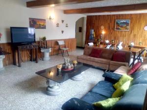 a living room with a couch and a tv at Hostal Los Volcanes in Guatemala