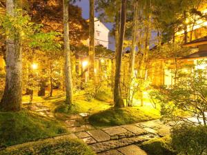 a stone path in a park with trees at night at Hoshi in Komatsu