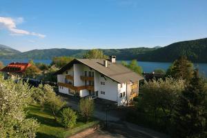 ミルシュタットにあるAppartementhaus Sonneの湖の景色を望む大きな白い家