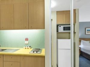 Una cocina con un refrigerador blanco y un microondas. en Waterfront Apartment 216, en The Entrance