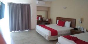 Habitación de hotel con 2 camas con almohadas rojas en Hotel JS, en Cocoyoc