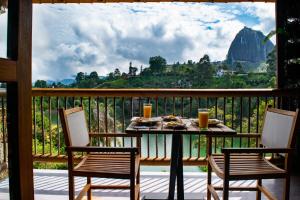 un tavolo su un balcone con vista sulle montagne di Sotavento Cabañas a Guatapé