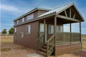 a small house with a porch and a deck at 077 Tiny Home nr Grand Canyon South Rim Sleeps 8 in Valle
