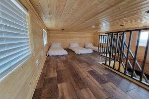 Duas camas num quarto com paredes e janelas de madeira em 077 Tiny Home nr Grand Canyon South Rim Sleeps 8 em Valle