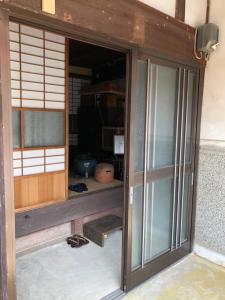 uma entrada para um quarto com portas de vidro em 古月(KozukI)久年庵 em Yamaguchi