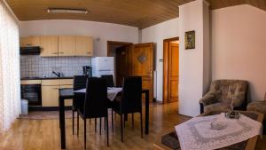 a kitchen and a dining room with a table and chairs at Apartment Pavlešić in Slunj