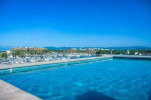 a large swimming pool next to a marina with boats at Modern stylish apt. steps away from the beach in Nuevo Vallarta