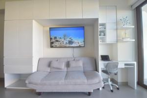 Televisyen dan/atau pusat hiburan di Modern stylish apt. steps away from the beach