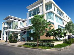 a large white building with a tree in front of it at Duplex 21 Apartment in Bangkok