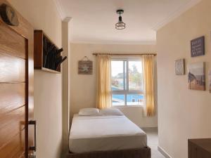 a small bedroom with a bed and a window at BlackPoint in Ballenita
