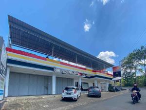 un hombre en una motocicleta estacionado frente a una gasolinera en ANA INN Ambarawa Mitra RedDoorz, en Semarang