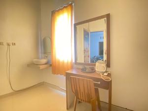 a bathroom with a vanity with a mirror and a sink at ANA INN Ambarawa Mitra RedDoorz in Semarang