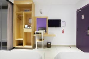 a room with a desk with a chair and a tv at East Sun Hotel Sekinchan Self Check In in Sekincan +45 photos