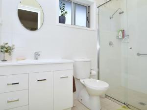 ein weißes Bad mit einem WC und einer Dusche in der Unterkunft Gartelmann Studio at Gartelmanns Wines in Lovedale