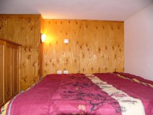 a bedroom with a large bed with wooden walls at Studio 6 pers. avec balcon - Studio 6 personnes MAE-9483 in Barèges