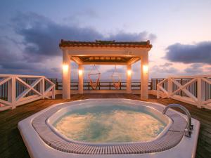een hot tub op een terras met een tuinhuisje bij Haruhoo Resort ISHIGAKI in Ishigaki Island