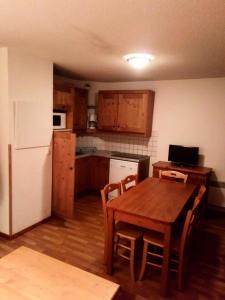 uma cozinha com uma mesa e um frigorífico branco em Appartement 6 pers. proche des pistes 71544 em Narreyroux