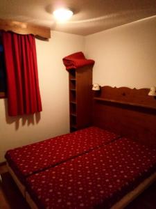 um quarto com uma cama vermelha e uma cortina vermelha em Appartement 6 pers. proche des pistes 71544 em Narreyroux