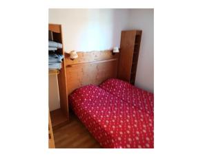 uma cama num quarto com um edredão vermelho em Appartement 6 pers. proche des pistes 71544 em Narreyroux