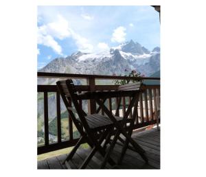 a wooden bench sitting on a deck with a view of mountains at Studio 5 pers. avec belle vue montagne 71063 in La Grave