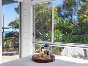 una mesa de desayuno con una cesta de café y zumo de naranja en Coorumbene 8 Scenic Way, en Normanville