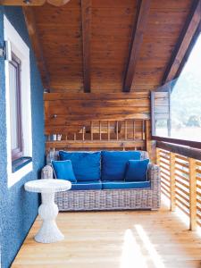 eine blaue Couch auf einer Veranda mit einem Tisch in der Unterkunft Sauna & Whirlpool - ALPENLIEBE APARTments in Inzell