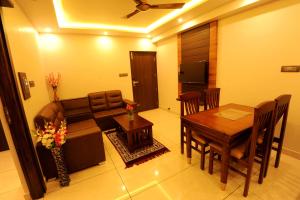 a living room with a couch and a table at MC Suites Mysuru in Mysore