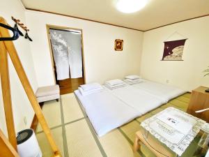 Postel nebo postele na pokoji v ubytování PetitHotel017全室ミニキッチン付きファミリルーム 飲食街中心 阿波踊り会館7分 文理 徳島大学 アスティとくしま車8分