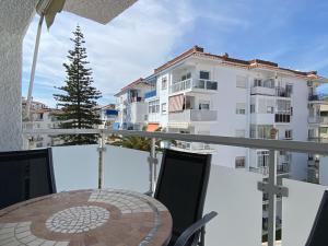 balkon ze stołem i krzesłami oraz budynek w obiekcie Apartamento La Torna Casasol w mieście Nerja