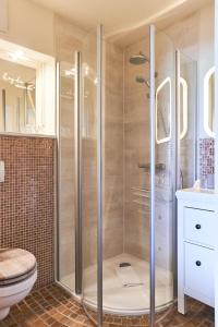 een badkamer met een douche, een toilet en een wastafel bij Strandhaus Hotel in Parey