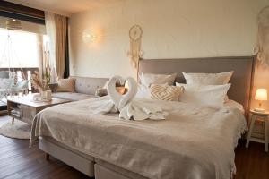 een slaapkamer met een groot bed met een zwaan erop bij Strandhaus Hotel in Parey