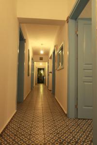 a hallway with a tile floor and a door at Çakir Bey Hotel in Alaçatı