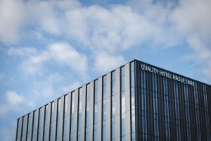 un bâtiment en verre avec un panneau en haut dans l'établissement Quality Hotel Hasle Linie, à Oslo