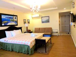 Villa Marinelli Bed and Breakfast في تاجيتاي: غرفة فندقية بسرير كبير واريكة