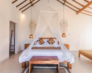 een slaapkamer met een bed met een klamboe bij The Kailas Ubud in Ubud