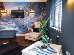 uma sala de estar com uma televisão e um sofá em Sauna & Whirlpool - ALPENLIEBE APARTments em Inzell