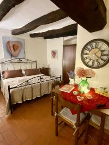 a bedroom with a bed and a clock on the wall at La Tana del Grillo in Pitigliano